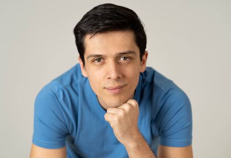 Close up portrait of carefree outgoing male student in casual blue t-shirt looking confident and...