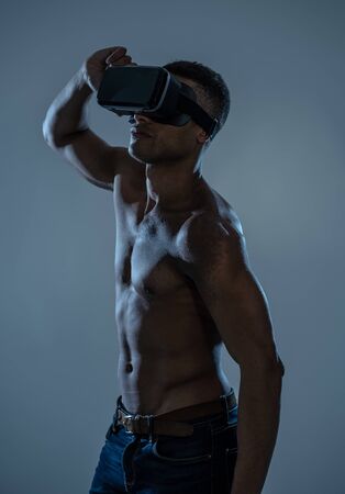 Attractive powerful african american man using augmented or VR goggles exploring new 3d world. Advertising of the power of virtual reality and augmented reality technology. 360 degree VR experiences.の写真素材