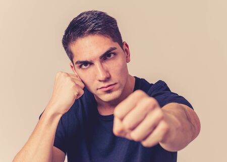 Close up portrait of an attractive young man with angry face looking furious in defence stance...