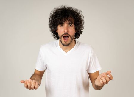 Portrait of funny attractive young man with happy and surprised face pointing and looking excited at...