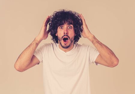 Portrait of funny attractive young man with happy and surprised face pointing and looking excited at...
