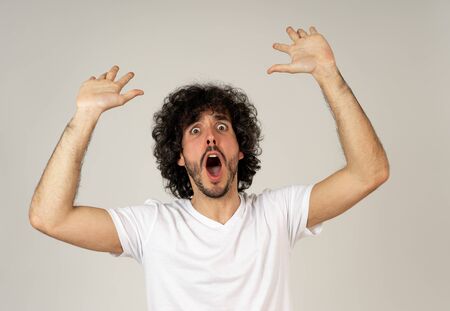 Portrait of funny attractive young man with happy and surprised face pointing and looking excited at something shocking and good. Human emotions, facial expressions. Advertising, sales or winning.の写真素材