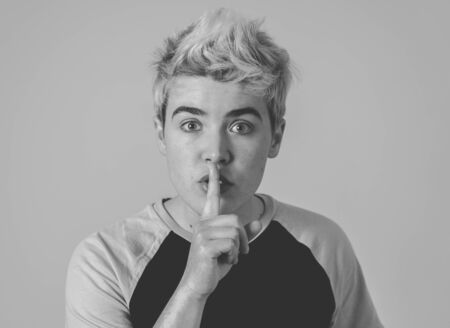 Transgender teenager making silence gesture in social taboo of gender identity concept. Trans boy...