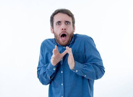 Portrait of young man in shock with scared face paralysed with fear and frightened face looking at something scaring. Human emotions feelings and facial expression. Isolated on neutral background.の写真素材