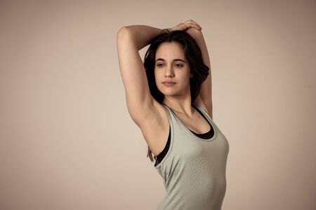 Beauty portrait of sport confident young latin woman wearing gym top looking sensual and fit. Studio shot of cheerful strong woman in sportswear looking healthy and sexy. In fitness Body care concept.の写真素材