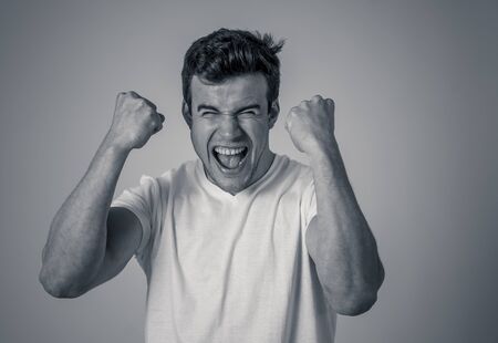 Portrait of handsome shocked young man hearing good news, winning or having great success with surprised happy face. Making cheerful gestures. Facial Expression, Human Emotions and celebration.の写真素材