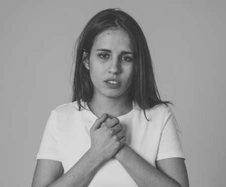 Portrait of a young sad woman, serious and concerned, looking worried and thoughtful. Feeling emotional pain, sorrow and depression. With copy space. In facial expressions and human emotions concept.の写真素材