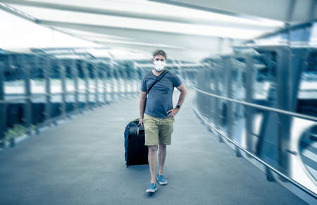 Coronavirus outbreak travel ban and restrictions. Traveler man with face mask at international...