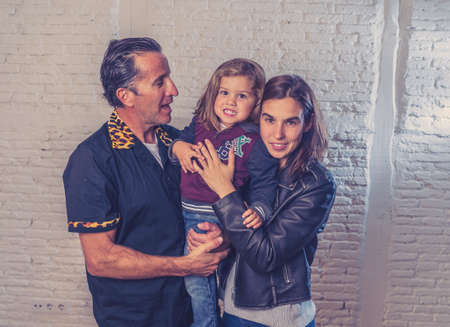 COVID-19 Lockdown. Cool family portrait of Mom dad and cute girl staying at home during coronavirus Outbreak helping to stop the virus spread. STAY HOME STAY SAFE and SAVE LIVES worldwide campaign.の写真素材