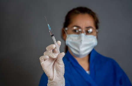 COVID-19 Coronavirus Vaccine. Doctor scientist with syringe analyzing virus Sars-CoV-2 in research for vaccine to be ready for clinical trial. Female researcher testing potential vaccine at the lab.の写真素材