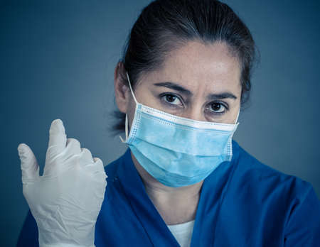 COVID-19. Exhausted Doctor looking worried as the coronavirus infected cases and death tolls rises. Emotional stressed of health workers needing support, Personal Protective gear and medical supplies.の写真素材