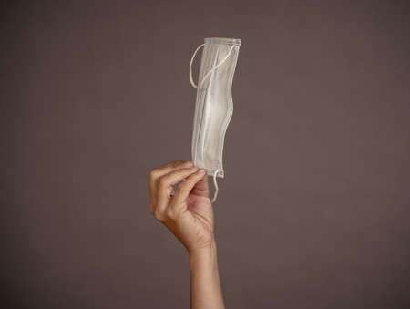 Coronavirus disease outbreak. Hand holding face surgical mask. Stop the virus spread, Protect yourself and others from COVID-19 and Lack of PPE personal protective equipment supplies concept.の写真素材