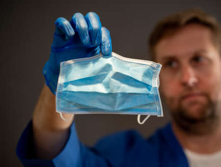 COVID-19. Doctor or nurse holding face surgical mask. Stop the virus spread, Protect yourself and...