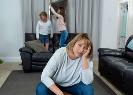 Stressed out parents struggling with having the children at home during Coronavirus self-isolation. Mother and father trying to cope with anxious kids during quarantine. COVID-19 Health crisis impact.の写真素材