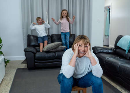 Stressed out parents struggling with having the children at home during Coronavirus self-isolation. Mother and father trying to cope with anxious kids during quarantine. COVID-19 Health crisis impact.の写真素材