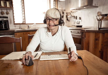 COVID-19 Outbreak. Woman on laptop working from home on video conference with work team during...