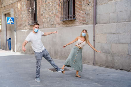 Safer way of greeting in the New Normal. Man and woman foot shaking and elbow bumping keeping social distancing to avoid Coronavirus spread. COVID-19 outbreak and social interactions.の写真素材