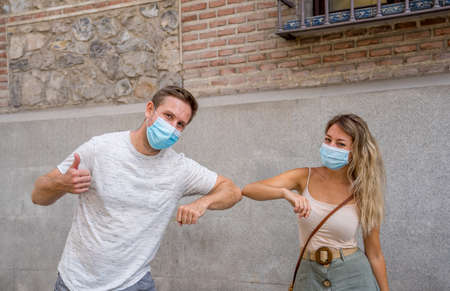 Safer way of greeting in the New Normal. Man and woman foot shaking and elbow bumping keeping social distancing to avoid Coronavirus spread. COVID-19 outbreak and social interactions.の写真素材