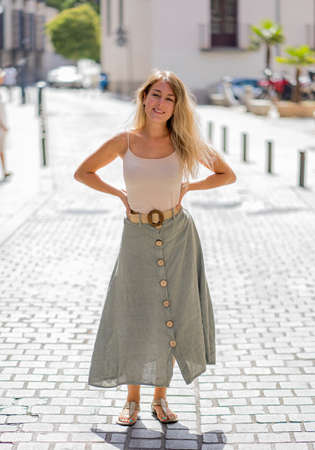 Outdoors full length portrait of young attractive woman with beautiful blonde hair and sensual smile. Female model posing with natural beauty and light. Real People, beauty care, fashion and lifestyle.の写真素材