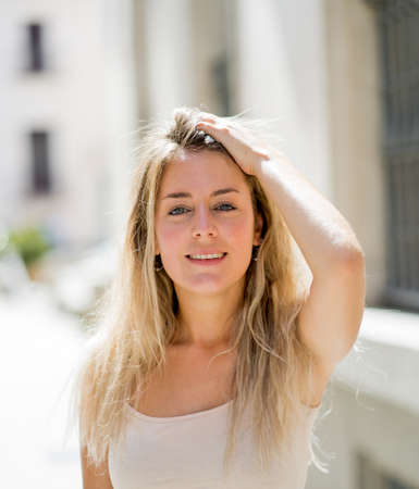 Outdoors close up portrait of young attractive woman with beautiful blonde hair and sensual smile. Female model posing with natural beauty and light. Real People, beauty care, fashion and lifestyle.の写真素材