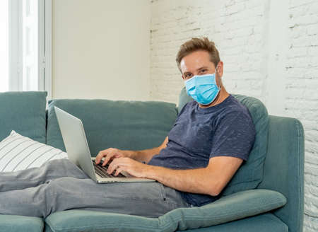 Happy business man on laptop working from home. Freelancer on computer on a video conference with employees working remotely in coronavirus Lockdown, Social Distancing and New Normal concept.の写真素材