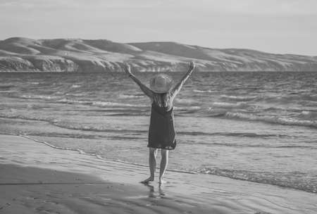 Happy attractive Mature woman in red dress enjoying outdoors and freedom on the beachの写真素材