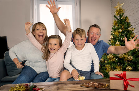 Happy family on video call call celebrating virtual christmas online due to social distancing and coronavirus lockdown and quarantines. Screen device view image of happy virtual celebrations.の写真素材
