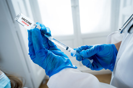 Nurse testing young girl for coronavirus infection taking rapid COVID-19 test. Doctor performing nasal swab on child taking example to analyze if patient is positive for the infectious disease.の写真素材