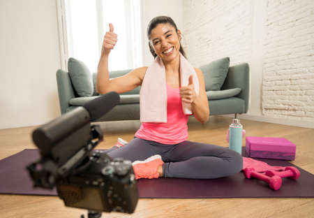 Attractive Woman personal trainer coach recording on camera new content for online fitness business. Freelance filming online training program with virtual workout and exercises for social media.の写真素材