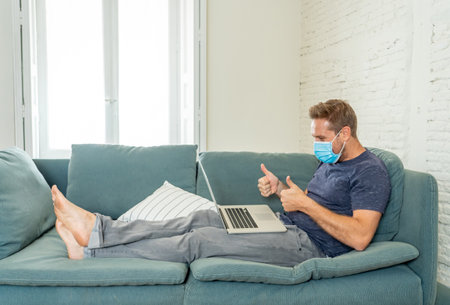 Happy business man on laptop working from home. Freelancer on computer on a video conference with employees working remotely in coronavirus Lockdown, Social Distancing and New Normal concept.の写真素材