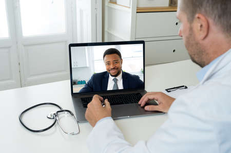 Screen laptop with afro american man video calling physician for medical advice or treatment....
