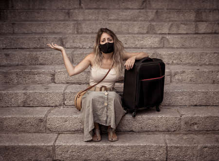Summer Travel during virus and tourism. Sad Tourist woman with luggage and facemask could not get abroad over summer holidays.の写真素材