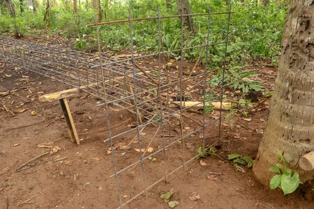 Iron steel for making skeleton of concrete column on wooden support. It was tied together using tiny wires. Reinforcement of concrete work. Using steel wire for securing steel barsの写真素材