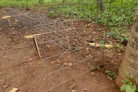 Iron steel for making skeleton of concrete column on wooden support. It was tied together using tiny wires. Reinforcement of concrete work. Using steel wire for securing steel barsの写真素材