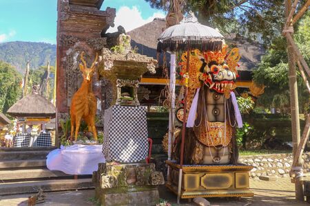A statue of Barong in a Hindu temple that represents good and positive energy. A temple wrapped in a black-and-white square pattern that helps drive away evil spirits and drive away negative energy.の写真素材
