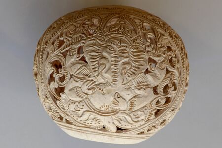 Close up of ornamental shell for candle. Hand carved decorative ornaments and motif of Hindu God...