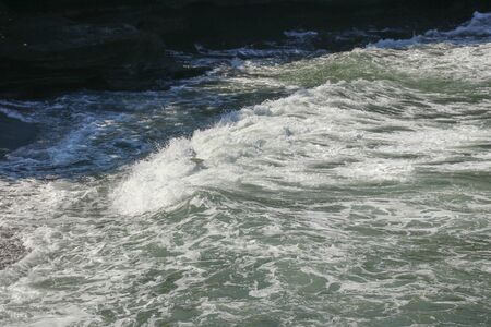 An Unidentified Surfer Falling Off the Surfboard. Batu Bolong Beach, Bali, Indonesia. A surfer is...