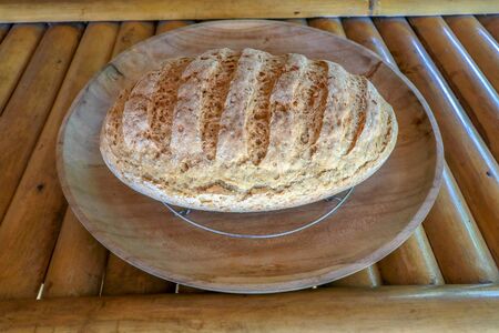 Fresh homemade bread made of wheat and rye flour. Sliced bread in a wicker basket. Bowl with salt....