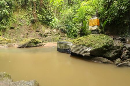 River and ancient hindu altar and Goa Giri temple in the forest Beautiful river flow surrounded by...