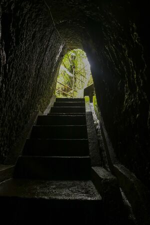 Historic tunnel carved into the rock in the jungle. A hand-carved tunnel in a rock created by the Dutch a hundred years ago on the island of Bali, Insdonesia.