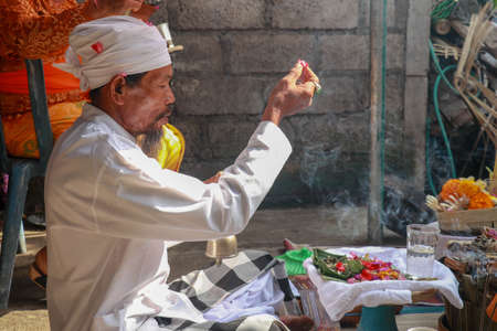 Close up of a Balinese pedanda during prayer. side view of a hindu priest performing a ceremony. A...