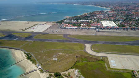 Aerial view of the runway from the top of the tower of the international airport controls Bali with a parked plane and several planes are on the runway. Aerial view to Ngurah Rai airport, Indonesiaの写真素材