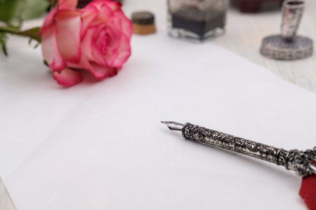 Greeting card with pen, blue gift box, pink and white roseの写真素材