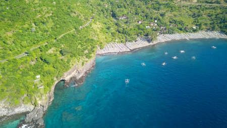 Caves on the rocky shore. Tropical paradise in Bali. Aerial drone View a cave on the coast of the...