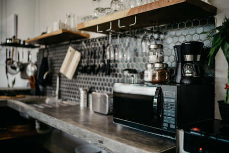 Close-up microwave and stainless electric kettle. Microwave and kitchen appliances in a modern dark kitchenの写真素材