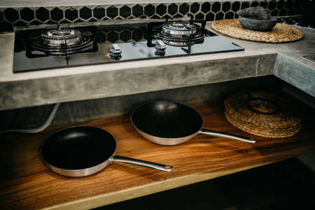 Pans in a shelf under a gas stove. Modern design of luxury kitchenの写真素材