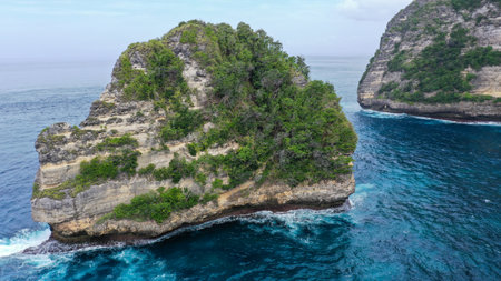 Aerial view of big cliff on coast, dron fly through hole in cliff. Zoom-out of giant rock in Golden Bay to wide landscapeの写真素材