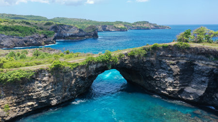Fly over rock arch over ocean in Broken Beach, Nusa Penida, Indonesia. High quality 4k footageの写真素材