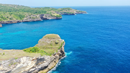 Aerial view by drone overlooking the sea. Rocky coast with high cliffs, Beach with hole on the cliff in Nusa Penida island, Bal Pasih Uug, Broken Beach, angels billabong. Bird eye viewの写真素材