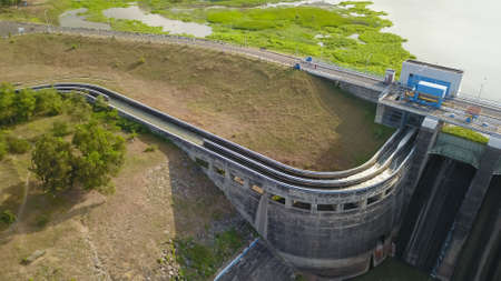 Water in dam concrete spillway infrastructure at reservoir. Waterfall and stream in side channel...